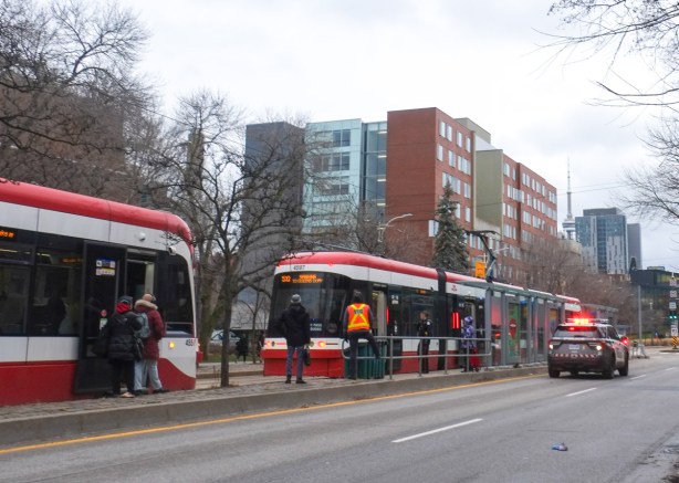 streetcars stopped on Spadina, police car with lights flashing stopped beside the one in front