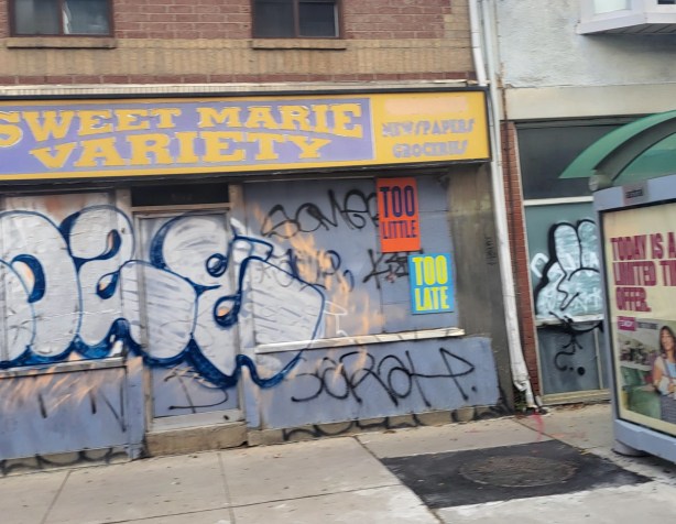 text on posters, graffiti, on boarded up windows