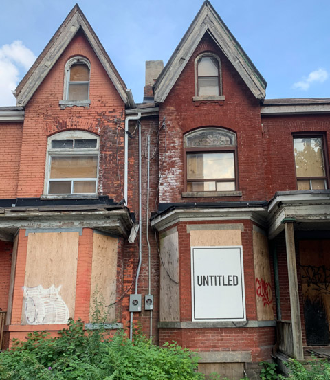 text on posters, graffiti, on boarded up windows