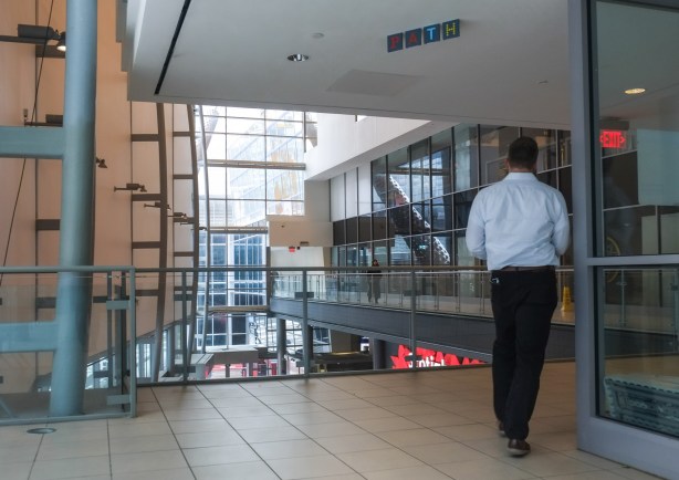 a man walks through the PATH system on the upper level of scotiabank arena, interior