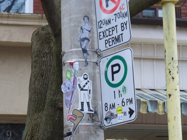 graffiti on a pole along with street signs