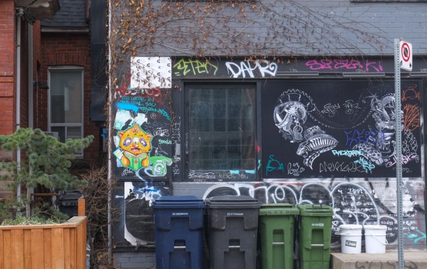 graffiti on a blackened window of an empty store in kensington, three pieces of graffiti on it, including a df606 david bowie in the center of an old rotary phone