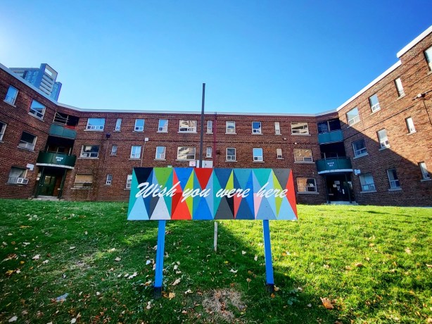 painted sign posted outside old brick regent Park building before it was demolished