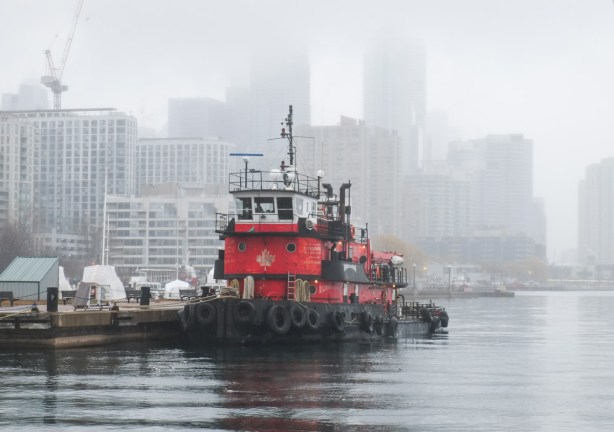 red fire boat docked at Toronto waterfront, on a foggy day