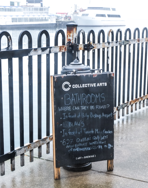 sign on sidewalk on waterfront re information on where to find a bathroom in the area 