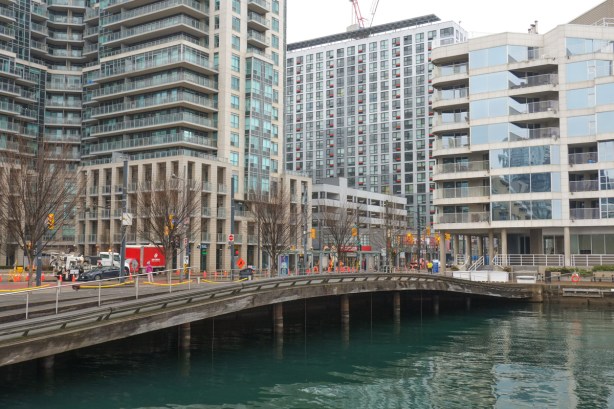 Spadina Wave Deck on Queens Quay, where the sidewalk arches up over the water, glass condos rise up in the background