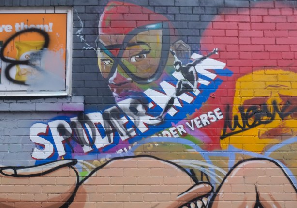 part of a mural about spiderman and the spiderverse but some of it has been tagged over