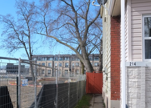 looking down the side of a house, to see new townhouses in the background