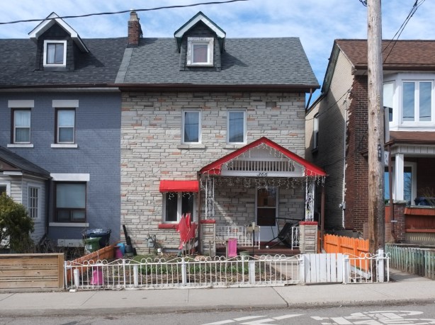 house on Sorauren, white fence in front, red trim on porch and awning over window