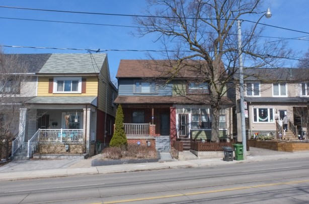 semi divided houses in a row on gerrard, two stories, with front porches,