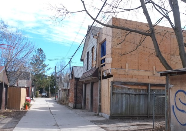infill housing being built in an alley, plywood