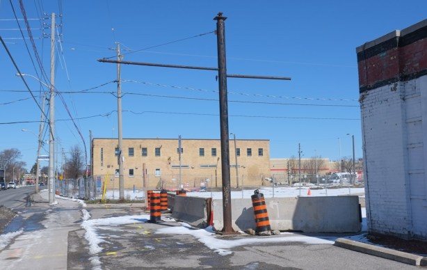 lowrise yellow brick building across a vacant lot covered with snow