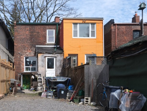 backyards, alley view, one with lots of stuff in the yard