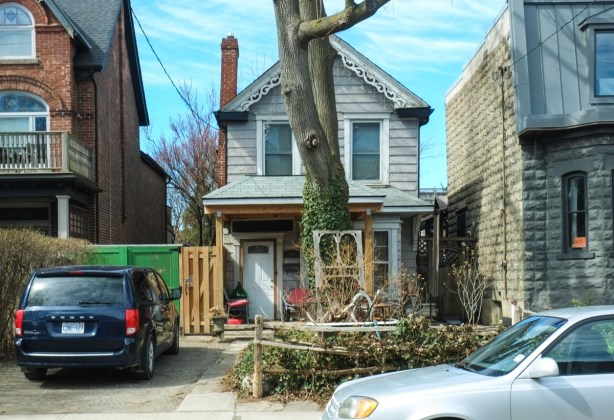 small narrow house, two storey, large tree in front, gingerbread trim under eaves, very small front yard,
