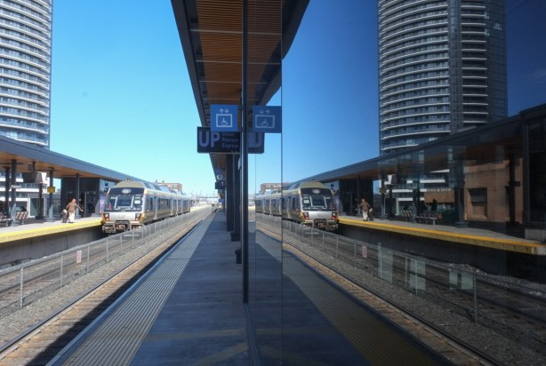 UP Express train in station, reflected in the windows of building on other side of tracks