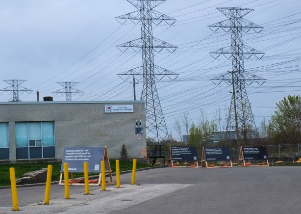 dead end of street, small building there is no longer open for business, signs for metrolinx construction of Ontario lone