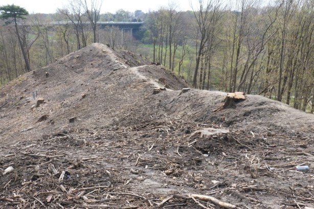 ridge of land, now cleared of trees, some debris remaining, dirt, Millwood bridge in background
