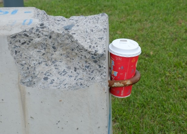 tims cup stuck in a metal loop attached to a block of concrete