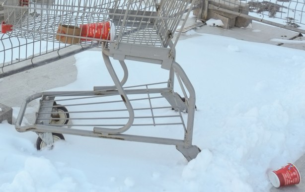 tims cups in a shopping cart and on the ground in the snow