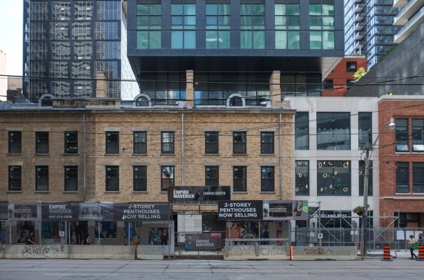 preserved row of brick buildings on king street, with glass and steel condo rising above and behind