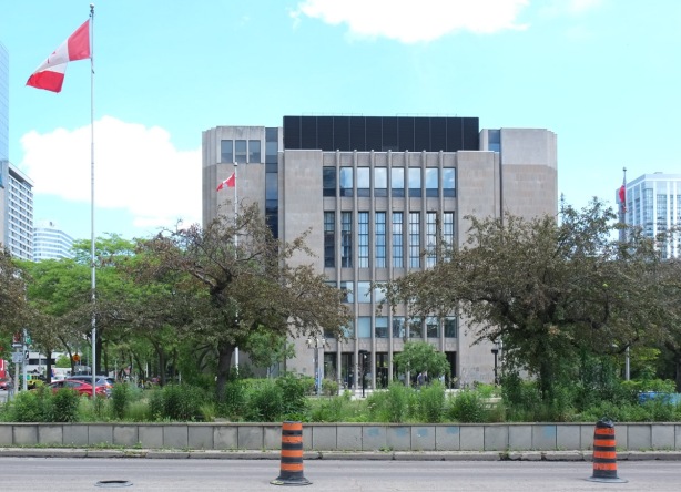 old court house building, or Toronto Courthouse, 361 University Ave., 8 storeys, clad with Queenston limestone, Canadian flag flying beside. 