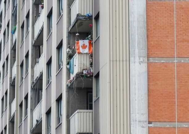 balcony on a high rise apartment building that has a large Canadian flag