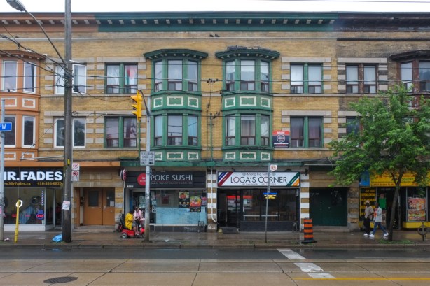row of brick apartments and store fronts at ground level. 