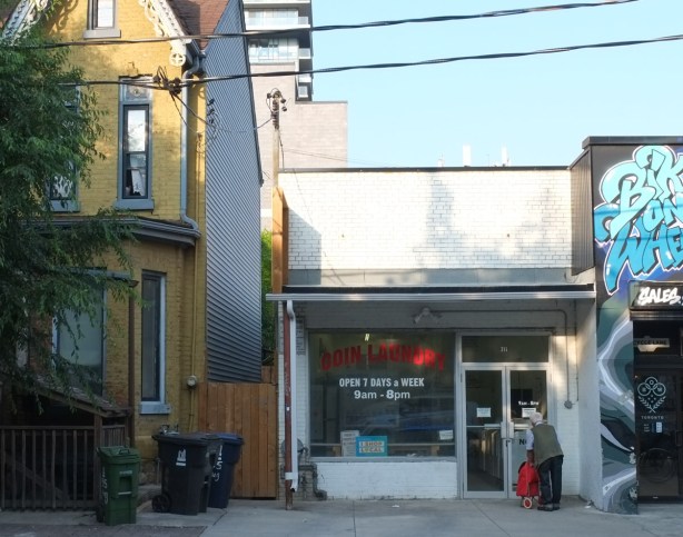 man with red bag outside a coin laundry in kensington