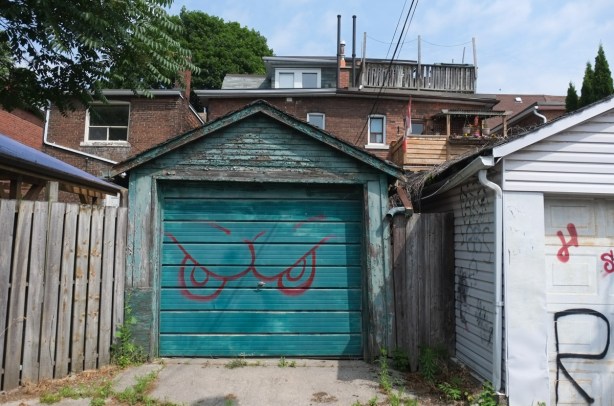 teal coloured garage door with eyes spray painted on it