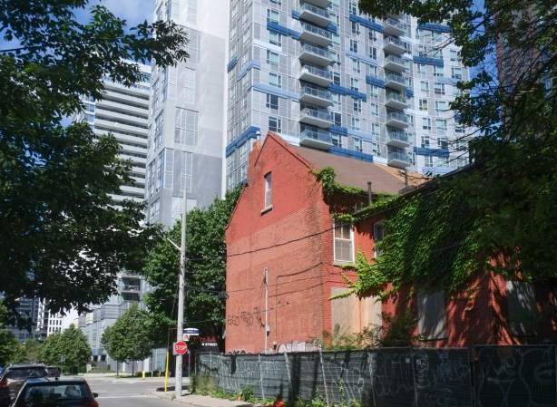 mark street approaching river street, side of red brick house, with new condo in the background