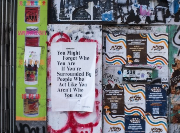 poster on an exterior wall, lots of text that says 