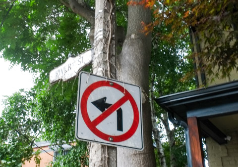 River street street sign, with a no left turn sign under it