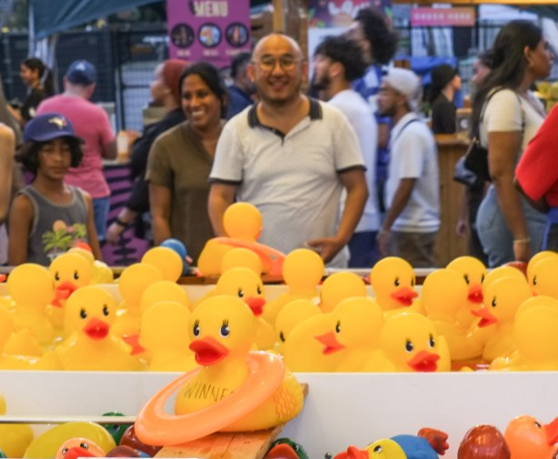toss a ring around a yellow rubber ducky midway game, with people behind