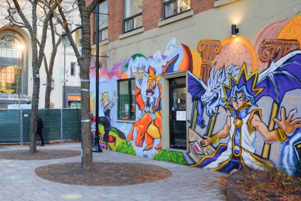 on a wall beside a pedestrian area, a mural featuring gaming characters, pokemon, etc