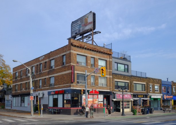 northeast corner of danforth and eaton avenue, 3 storey brick building, Papa Johns pizza on ground floor, Mr. Pide restaurant (now closed), Black Pot lounge, an empty storefront and an Asian (Korean?) restaurant.