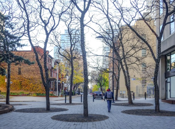 person walking through pedestrian zone between yonge street and sheard street at the end of mcgill
