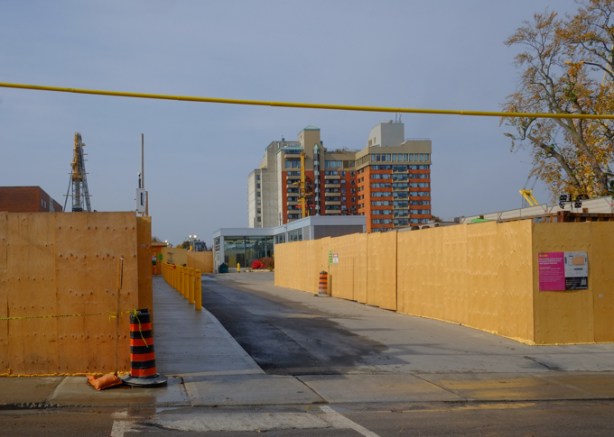 Eaton Ave entrance to Pape subway station, lined by construction hoardings, plywood, Ontario Line subway construction site