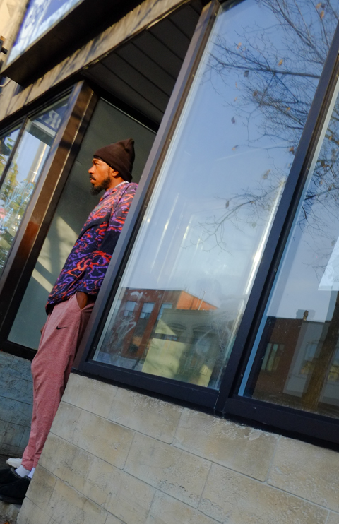 man standing outside a door of a store