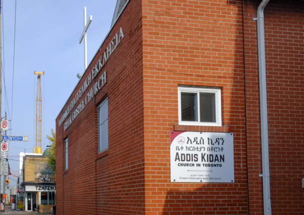Addis Kidan church on Pape Ave., red brick building with small white cross on roof