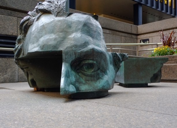 weathered bronze sculpture of upper part of man's face