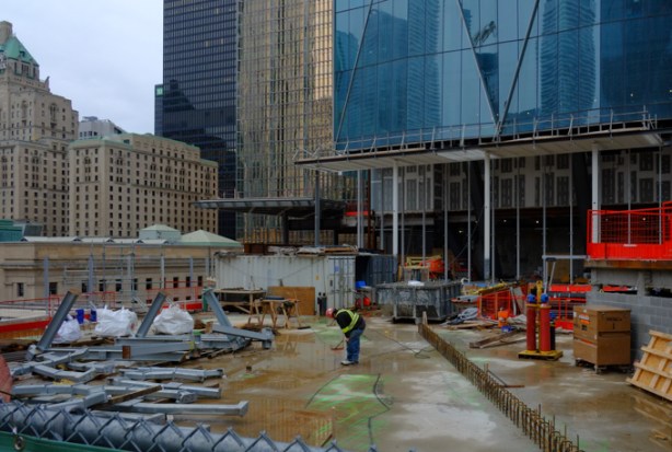 man working at construction site, park above the railway tracks at part 2 of cibc square, on the north side of the tracks, gold coloured r b c building also in the photo as is Royal York Hotel