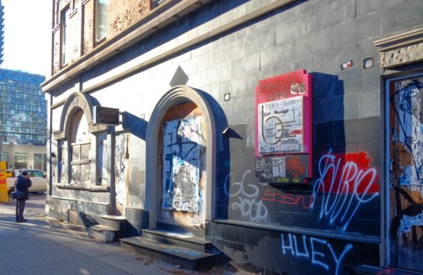 abandoned building with windows boarded up, graffiti