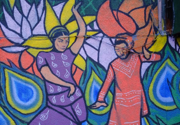 part of a mural in Little India, two people dancing, woman in purple sari, man in pinkish orange outfit