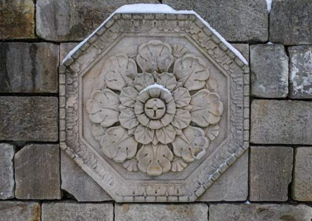 carved stone bas relief, octagon, with large floral motif in center