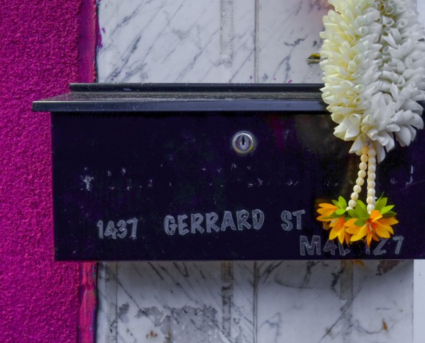 mailbox with white necklace like dangly thing, with fake orange flowers at the end