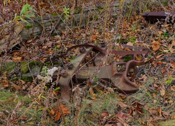 old piece of metal, remains of railway switch? or some piece of railway equipment, lying on the ground