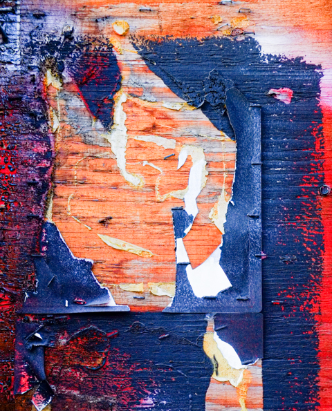 layers of ripped graffiti paste ups and posters on wall of an abandoned building at 55 Elm street