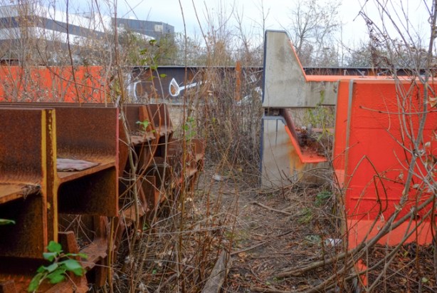 stacks of rusty metal girders beside a railway track