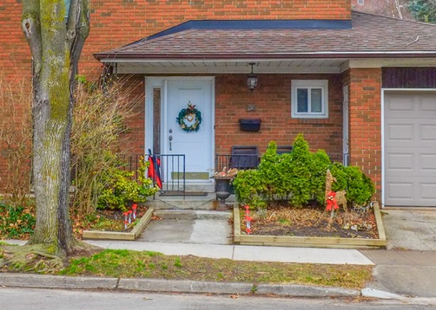 red brick house with a christmas decoration reindeer with a red bow around its neck