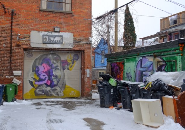 garage at 1 federal street, with mural on it, woman's portrait, gate beside garage, dead end street, other garages on the right side